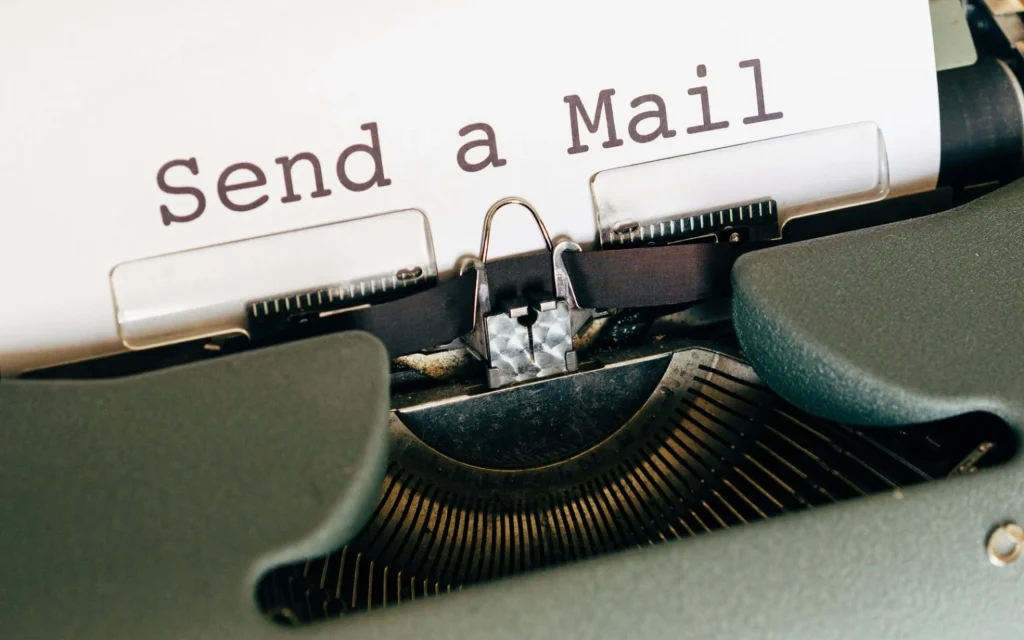 Schreibmaschine mit eine Papier im Lauf, auf welchem "Send a Mail" zu lesen ist.